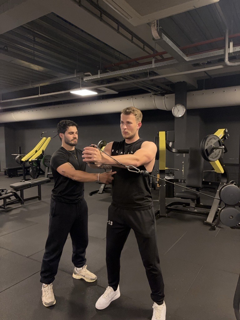 Ali begeleidt een klant tijdens personal training